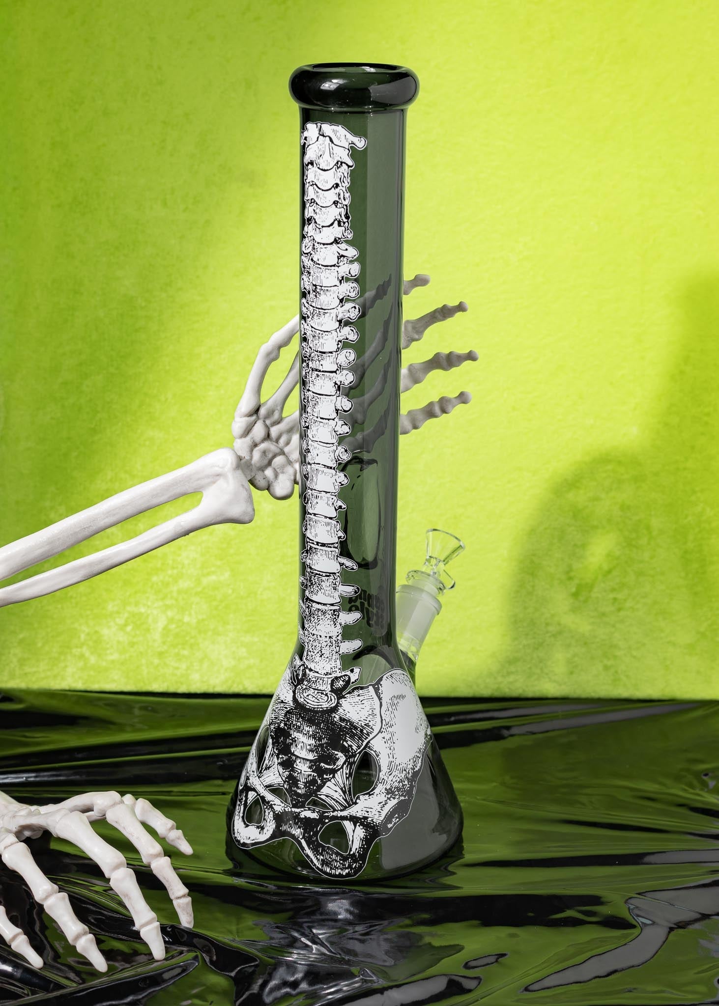 Glass bong with skeleton design on a green background